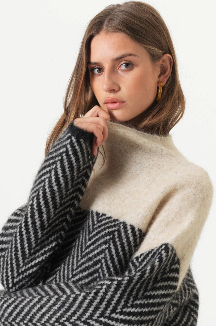Relaxed fit women's turtleneck sweater with stylish chevron knit. Long sleeve design for warm winter fashion.