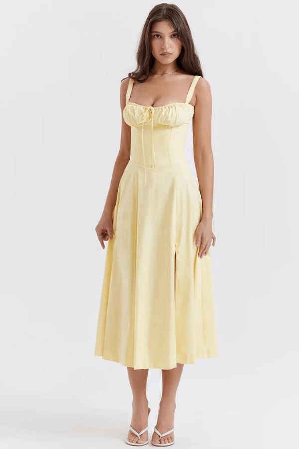 Flowy yellow women's elegant sun dress with corset detail. Comfortable midi dress for summer outings.