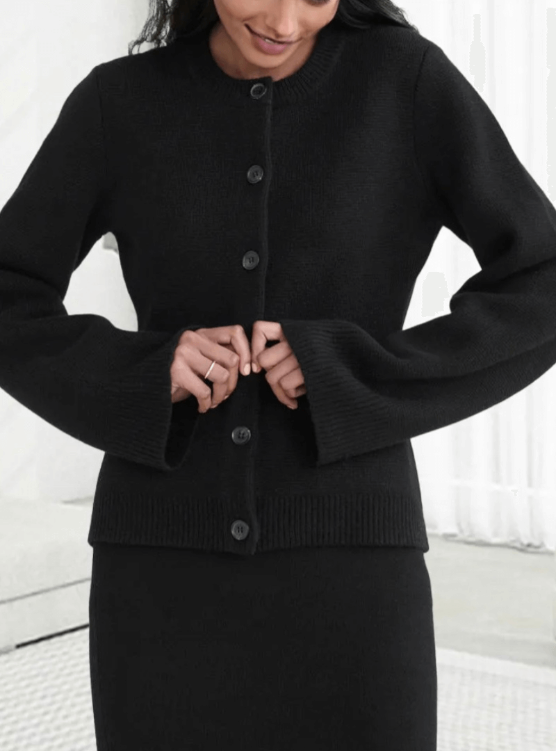 Cozy women's knit sweater with chic flare sleeves, perfect for a refined fall fashion look.