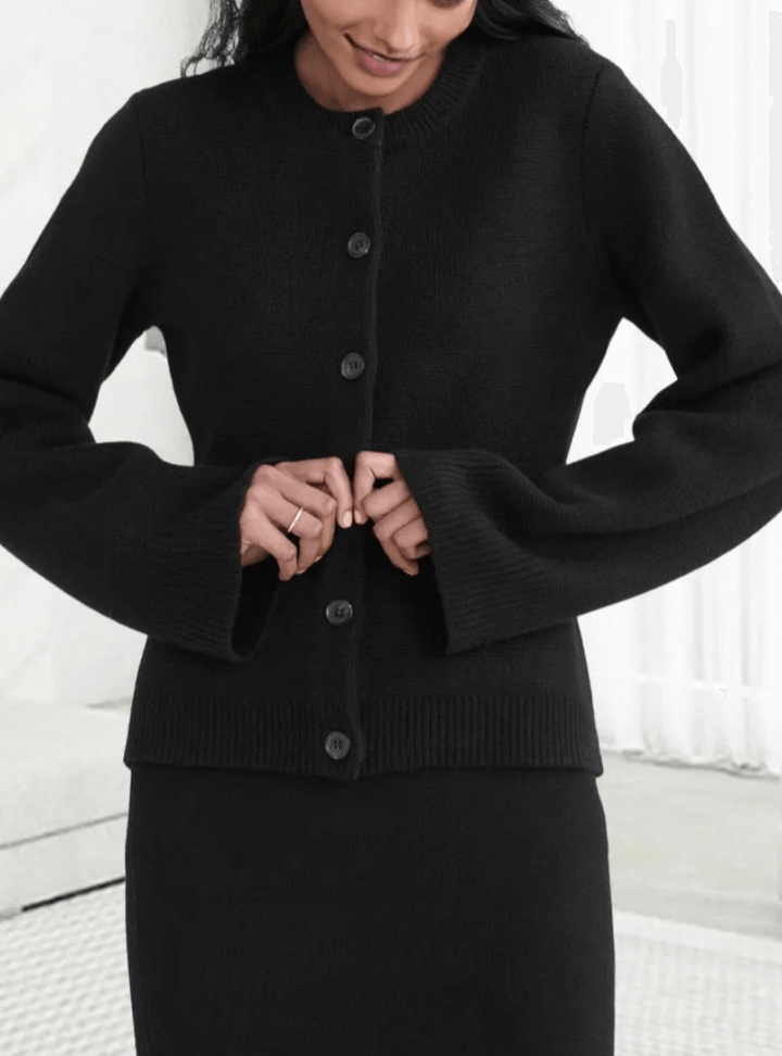 Cozy women's knit sweater with chic flare sleeves, perfect for a refined fall fashion look.