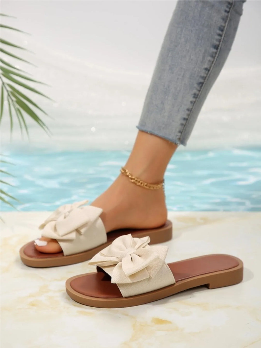 Comfortable women's slip-on bow slide sandals for summer. Stylish flat design ideal for beach, casual wear & travel.