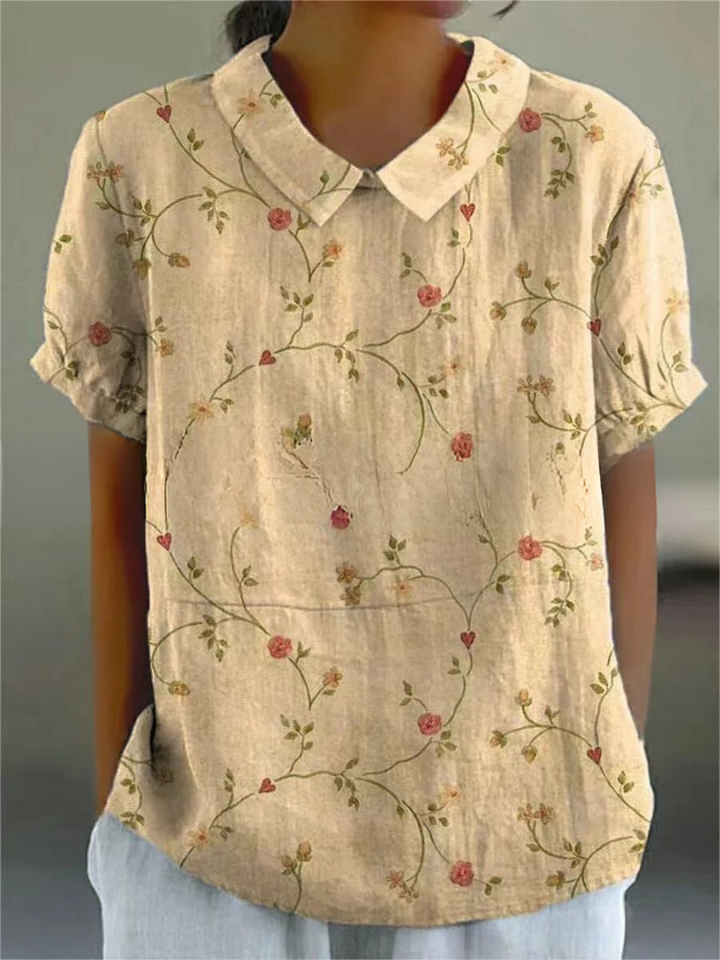 Close-up of the floral print and elegant Peter Pan collar detail on this women's short-sleeve blouse.