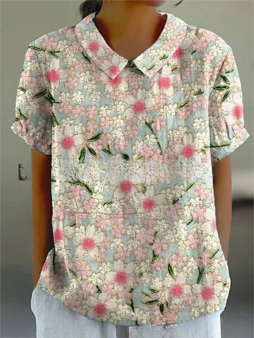 Full length view of a women's elegant floral blouse with Peter Pan collar, short sleeves, and vibrant print.
