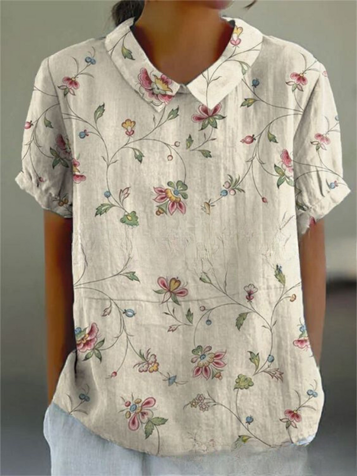 Stylish women's patterned blouse: short sleeves, floral design, and a unique Peter Pan collar.