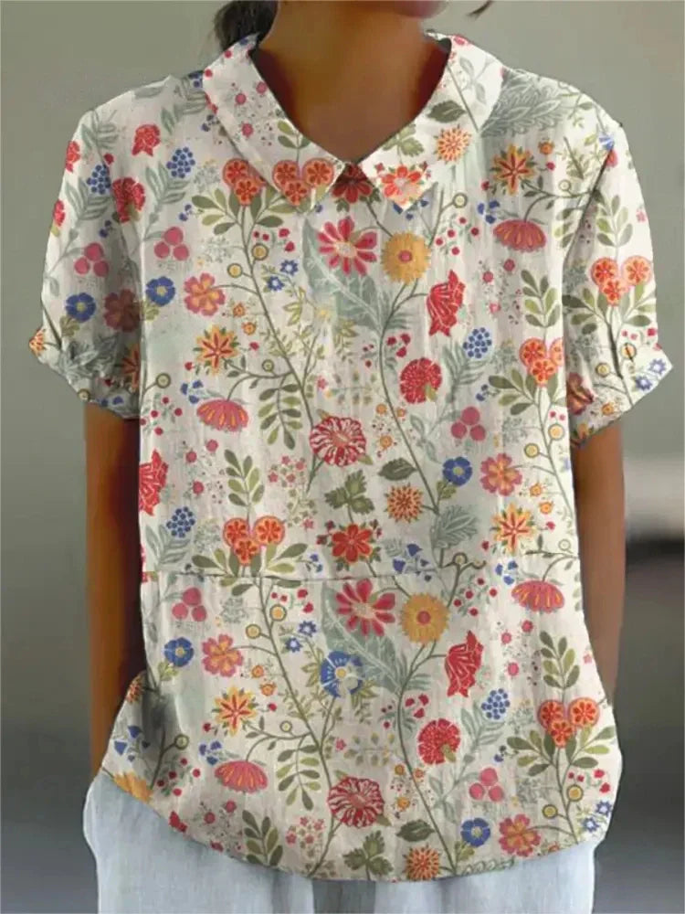 Side view of a women's chic floral print blouse, showcasing its Peter Pan collar and short sleeves.