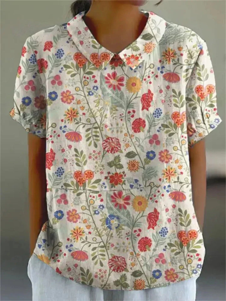 Side view of a women's chic floral print blouse, showcasing its Peter Pan collar and short sleeves.