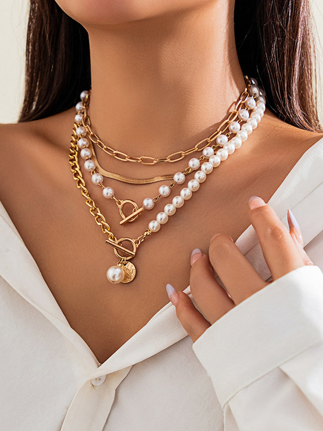Women's multi-layered gold chain necklace featuring delicate pearls. Stylish and versatile jewellery.