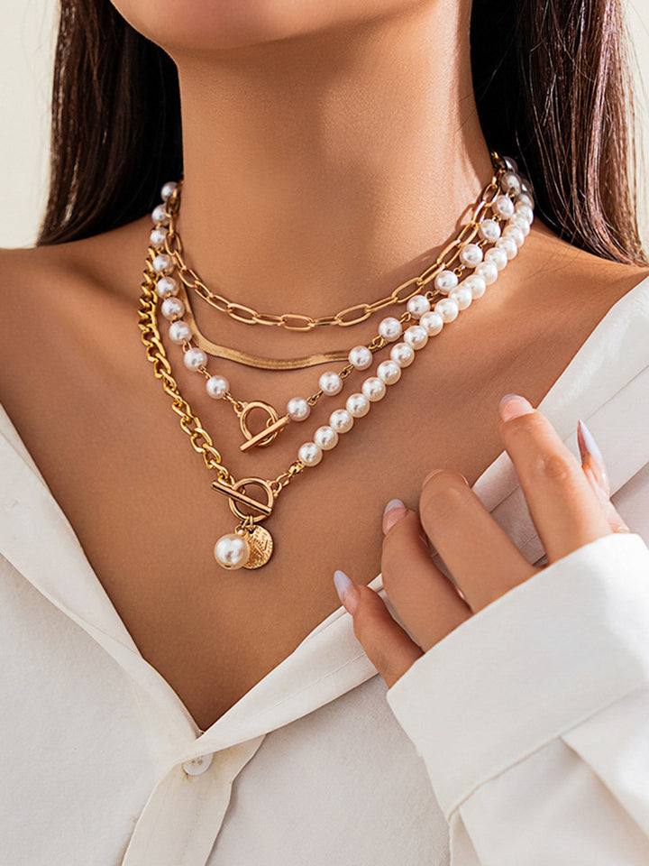 Women's multi-layered gold chain necklace featuring delicate pearls. Stylish and versatile jewellery.