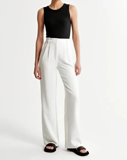 Fashionable women's high-waist wide-leg trousers with a modern pleated front, embodying an elegant, current trend.