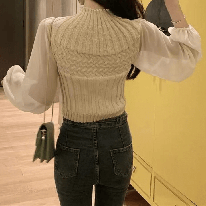 Women's knitted vest with delicate sheer sleeves, embodying modern elegance.