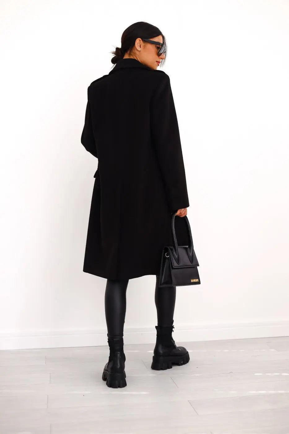 Tailored women's long double-breasted coat, a sophisticated outerwear statement piece for elegant winter fashion.