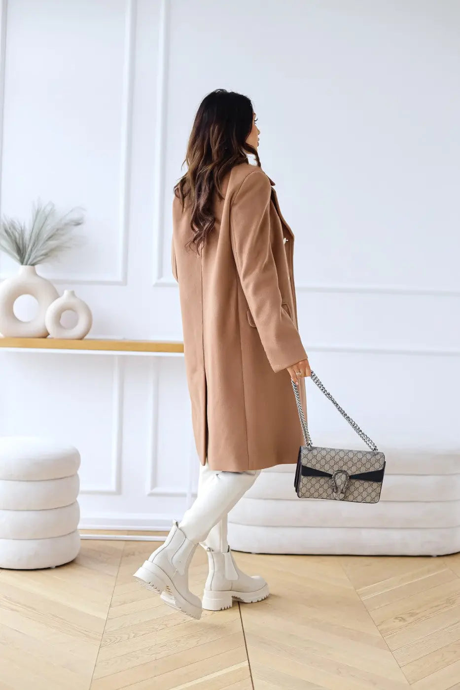 Close-up of classic double-breasted closure on an elegant women's long tailored coat. Winter fashion.
