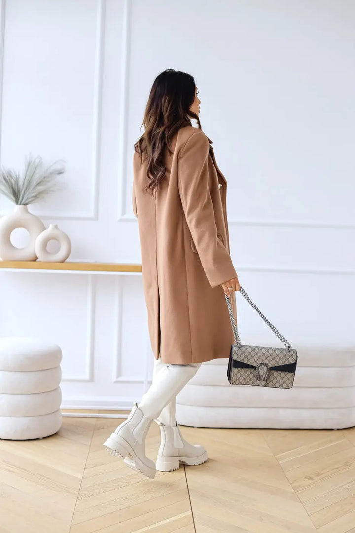 Close-up of classic double-breasted closure on an elegant women's long tailored coat. Winter fashion.