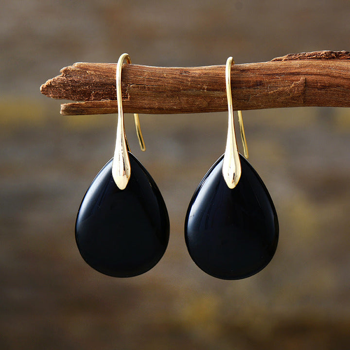 Close-up of elegant women's natural stone drop earrings. Teardrop dangle design, a stylish accessory for her.