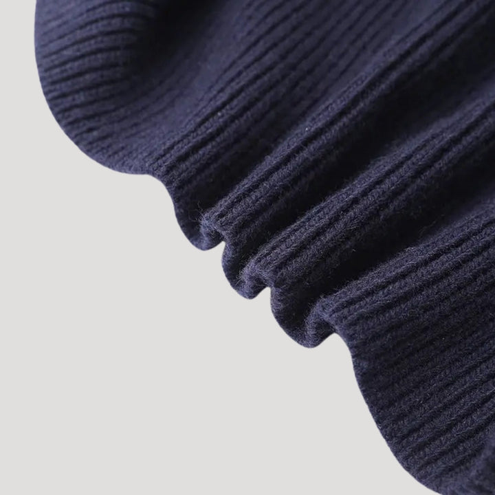 Close-up of the elegant contrast trim on a women's navy long sleeve cardigan, showing quality detail.
