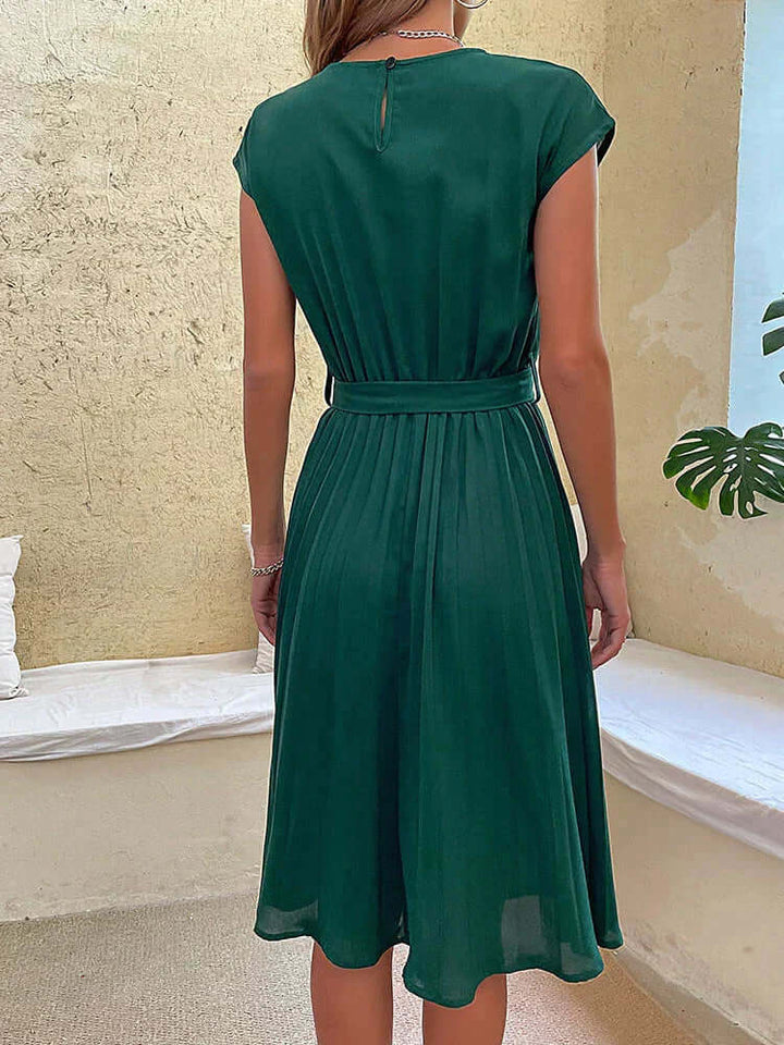 Flowy women's elegant midi dress, pleated skirt, cap sleeves, and tie waist detail for a sophisticated look.