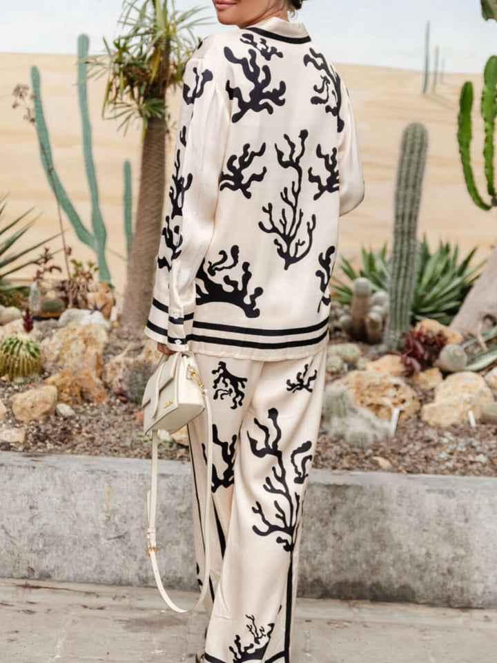 Stylish women's silk-like blouse and wide-leg trousers set. A chic, two-piece outfit for modern elegant fashion.