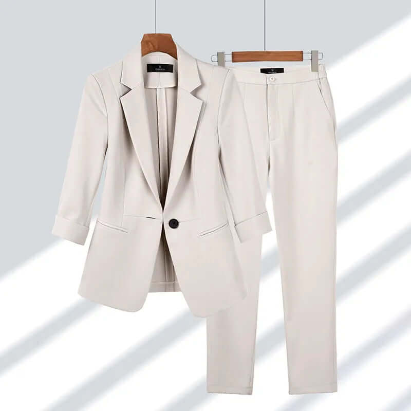 Elegant women's tailored suit set in black, featuring a fitted blazer and straight-leg pants for professional office wear.