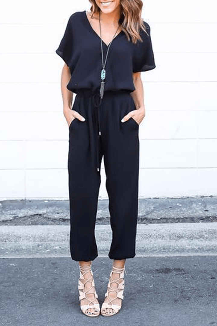 Women's elegant V-neck jumpsuit with crossed straps. Chic wide-leg style for formal or casual spring outfits.