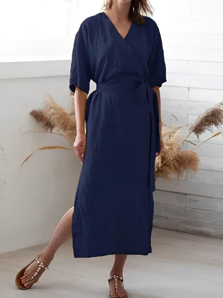 Full shot of a model wearing an elegant V-neck wrap dress with adjustable belt, showcasing its midi length.