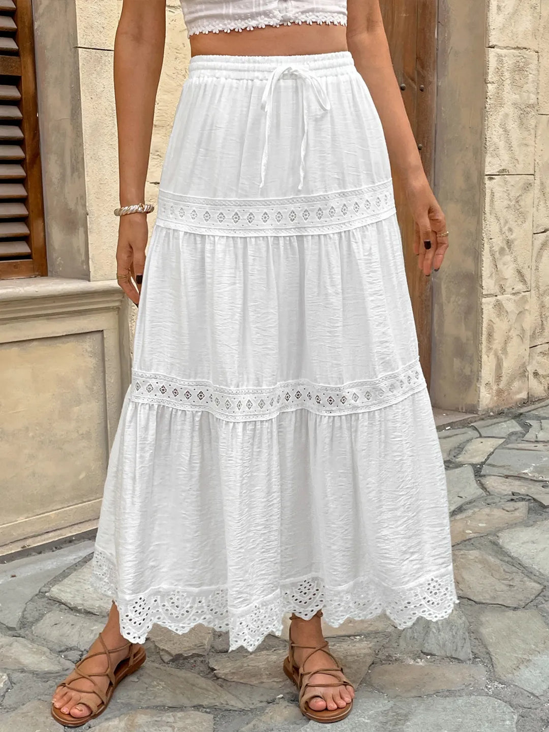 Elegant women's white lace maxi skirt, perfect for summer bohemian or vacation wear, with a flowy tiered design.