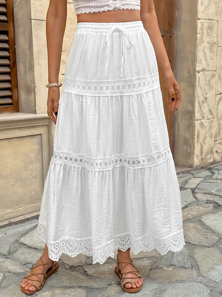 Elegant women's white lace maxi skirt, perfect for summer bohemian or vacation wear, with a flowy tiered design.