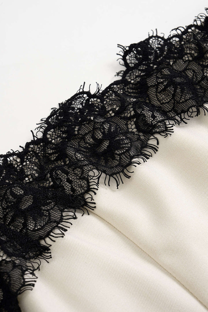 Sleeveless white midi cocktail dress with intricate black lace accents, ideal for elegant evening fashion.
