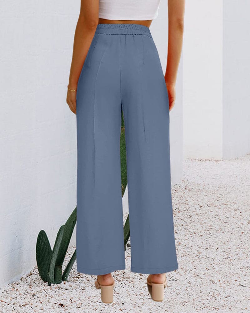 Women's high-waist wide-leg trousers in a flowing fabric, showcasing front pleats and a relaxed fit.