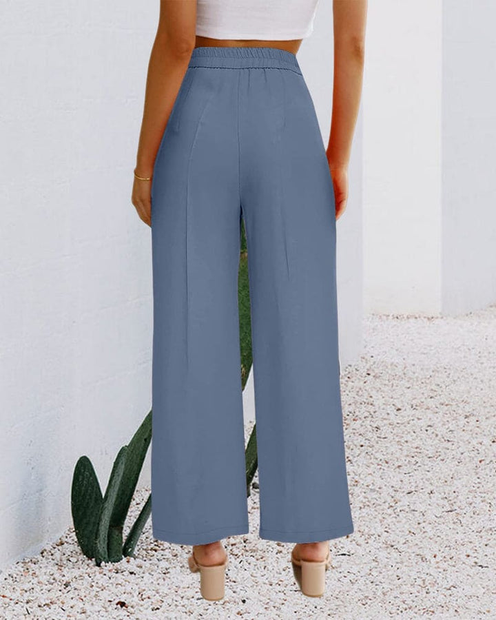 Women's high-waist wide-leg trousers in a flowing fabric, showcasing front pleats and a relaxed fit.