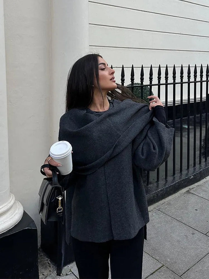 Asymmetrical stylish women's poncho, elegant outerwear for fall, a warm and fashionable wrap.