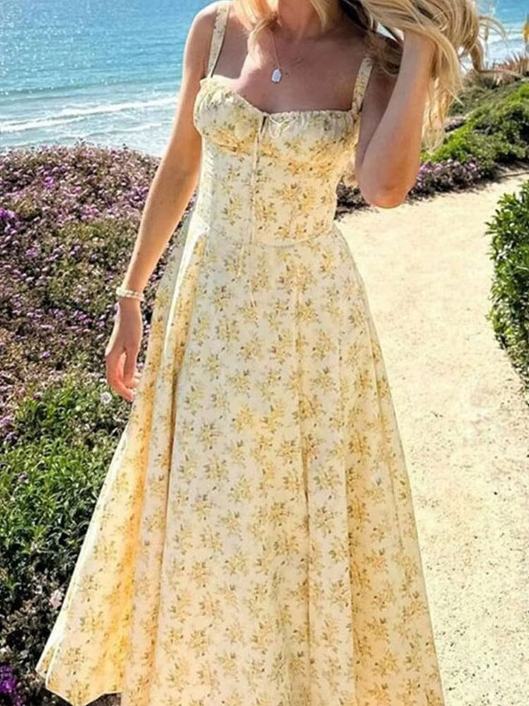 Chic yellow floral summer midi dress for women. Sleeveless design, ideal for elegant occasions or beach vacations.