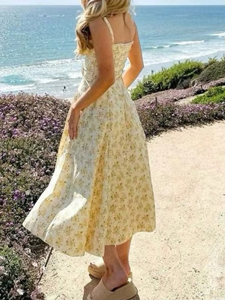Vibrant yellow floral midi dress for women, with a sleeveless and flowy design, great for summer events.