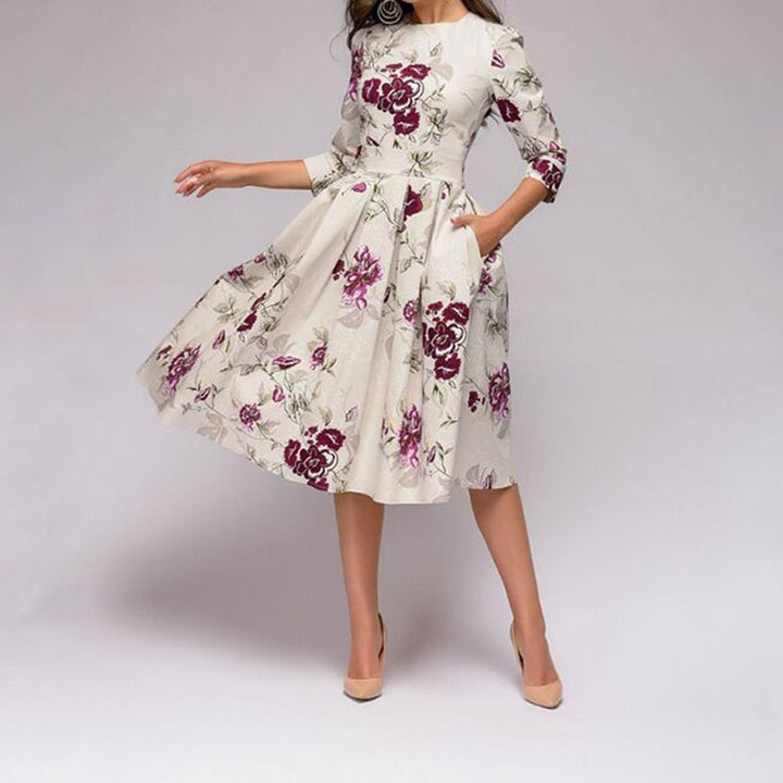 Women's A-line knee-length dress with a vibrant floral print, featuring 3/4 sleeves and a flattering fitted waist, ideal for spring occasions.