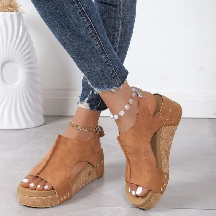 Stylish open-toe wedge sandals on a woman's foot, perfect for a fashionable summer look or vacation casual wear.