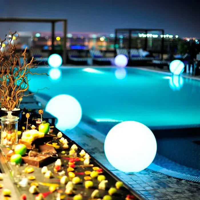 GlowSphere LED spherical light nestled among plants, providing soft, ambient garden lighting.