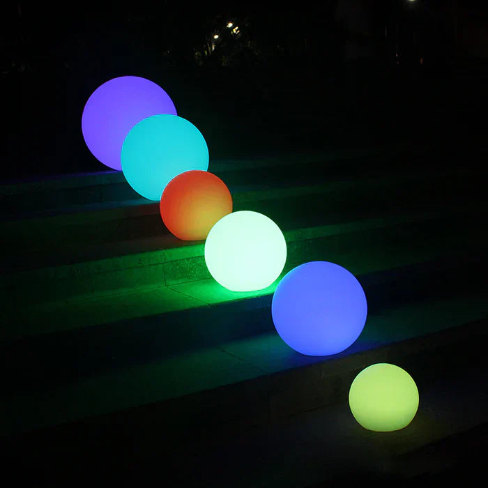 GlowSphere spherical garden lights lighting up a beautiful outdoor landscape, creating ambiance.