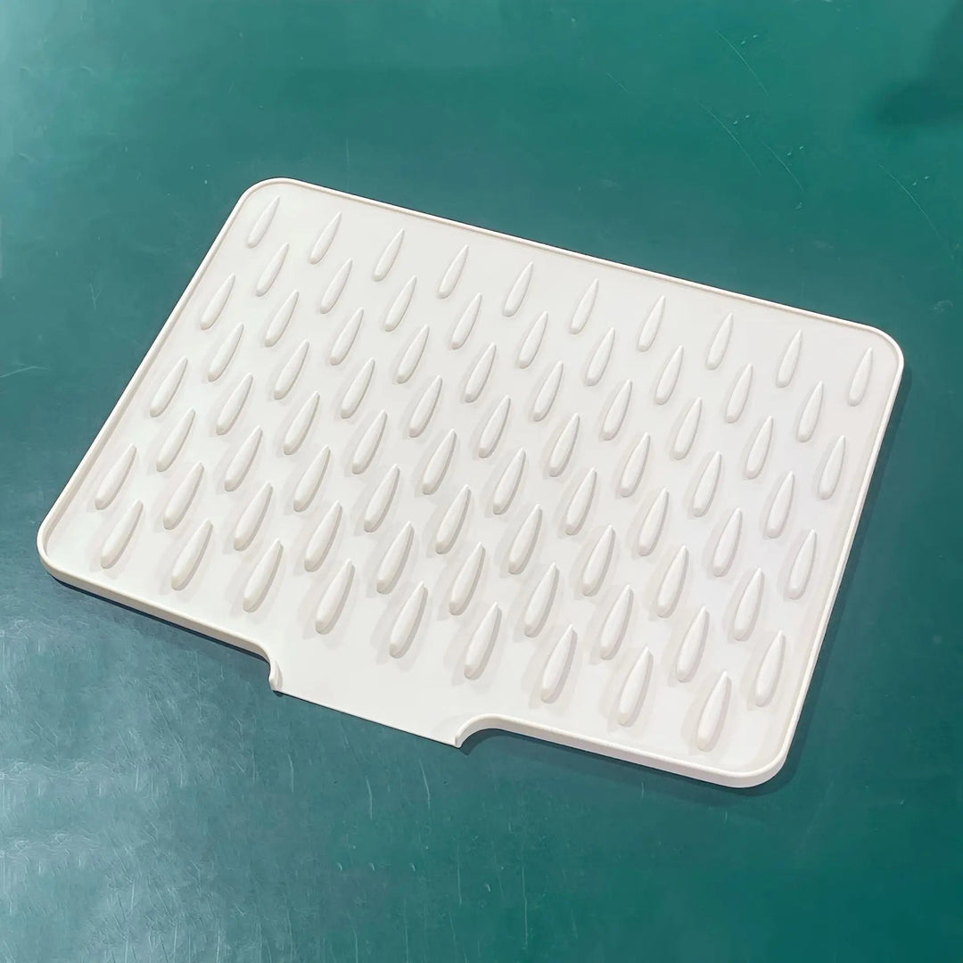 Grey heat-resistant silicone drying mat, perfect for kitchen counters. Non-slip dish mat protects surfaces & air dries dishes.