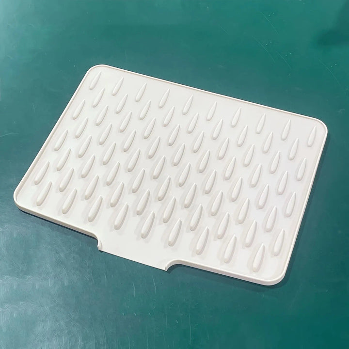 Grey heat-resistant silicone drying mat, perfect for kitchen counters. Non-slip dish mat protects surfaces & air dries dishes.