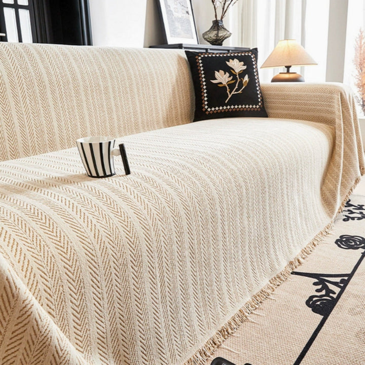 Herringbone chenille sofa cover with decorative tassels. Protects couch, adds living room elegance. Washable, pet-friendly.