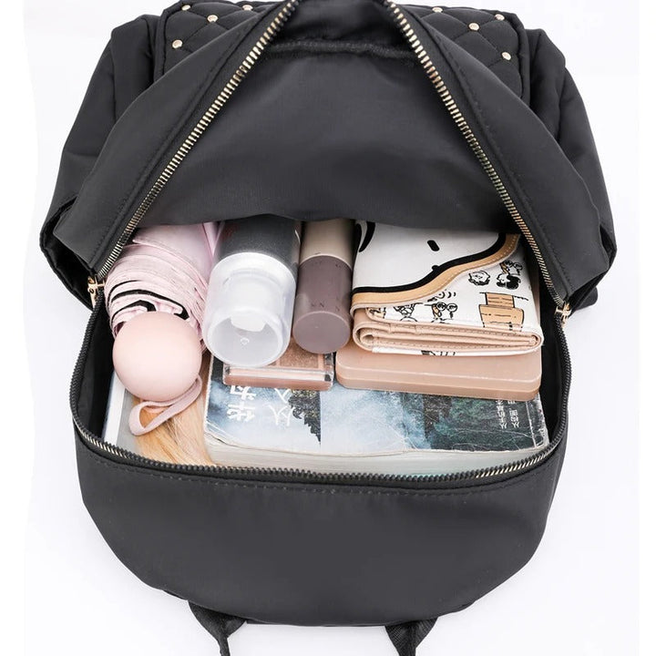 Woman commuting with a sleek black water-resistant nylon backpack, ideal for urban travel or school.