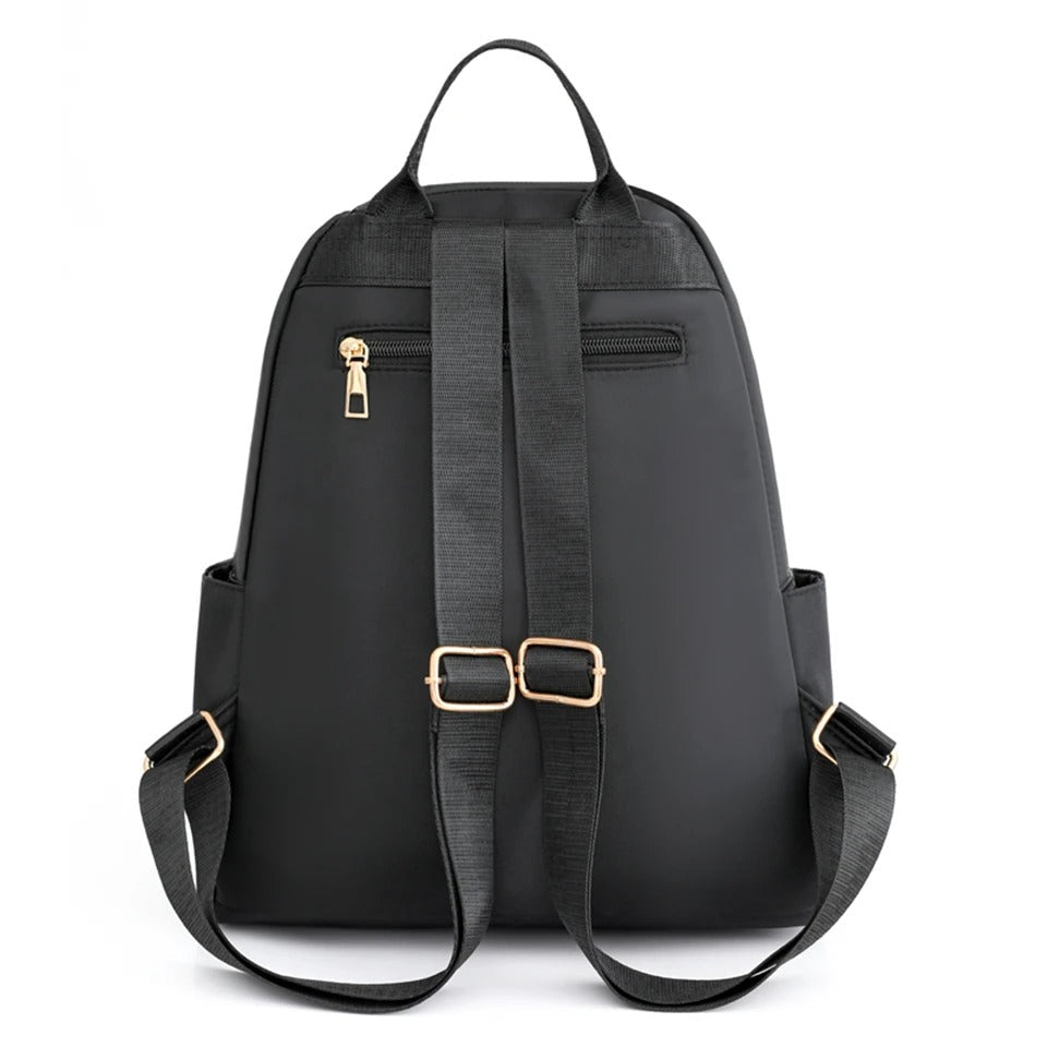 Close-up of durable, water-resistant nylon fabric & sturdy zippers on a women's everyday travel backpack.