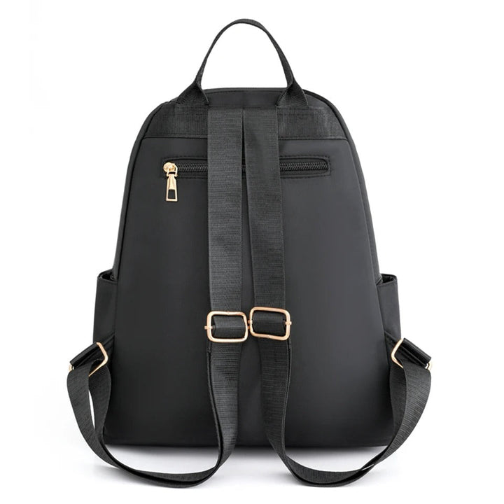 Close-up of durable, water-resistant nylon fabric & sturdy zippers on a women's everyday travel backpack.