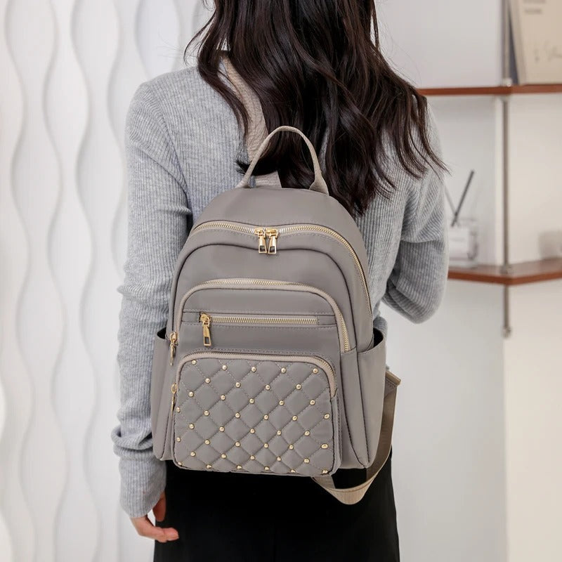 Front view of a black lightweight women's water-resistant nylon backpack, practical for school or adventures.