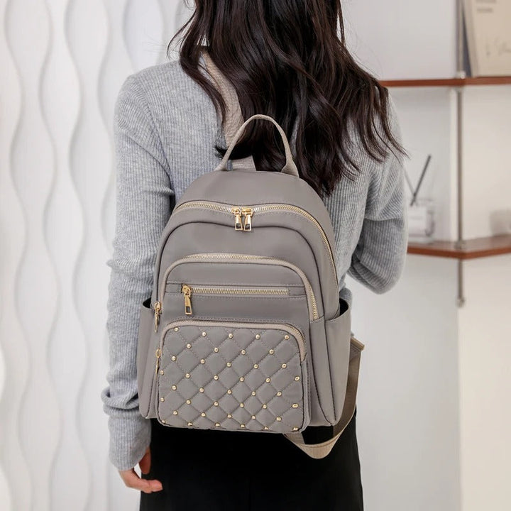 Front view of a black lightweight women's water-resistant nylon backpack, practical for school or adventures.