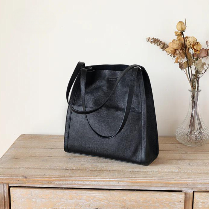 Woman carrying a large versatile shoulder tote bag, ideal for commuting or travel. Professional women's handbag.