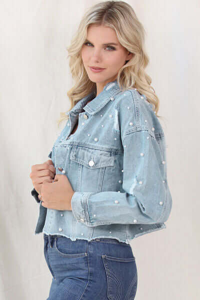 Elegant women's denim jacket, featuring chic pearl trim & light blue wash.