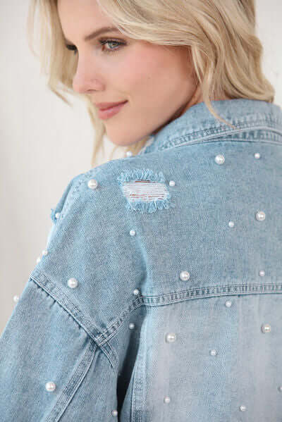 Ladies elegant light blue denim jacket with pearl trim, a stylish outerwear piece.