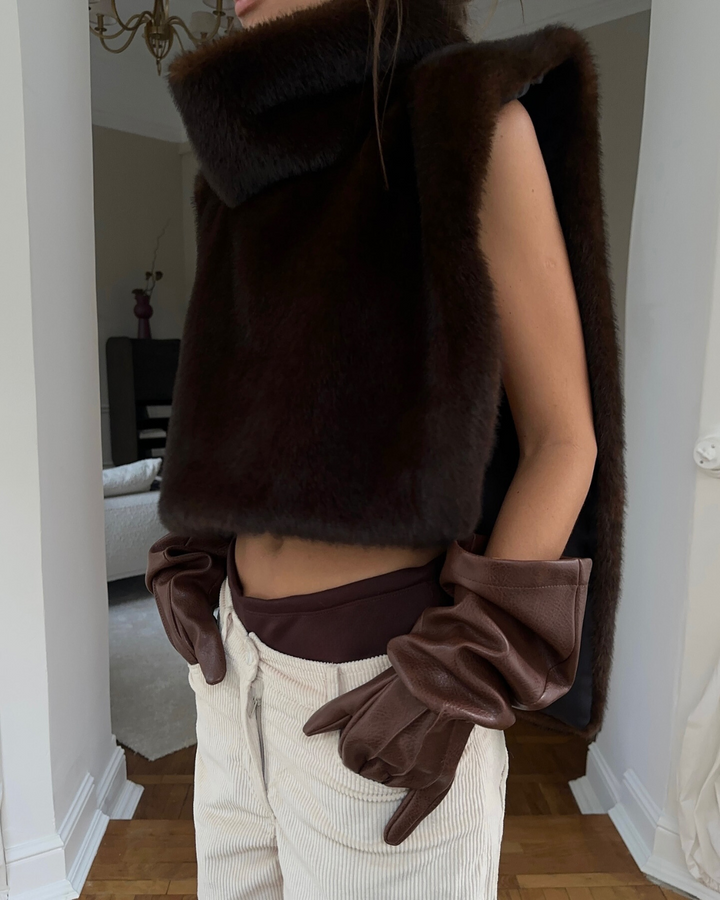 Elegant women's dark brown faux fur vest with a chic turtleneck, luxury winter outerwear.