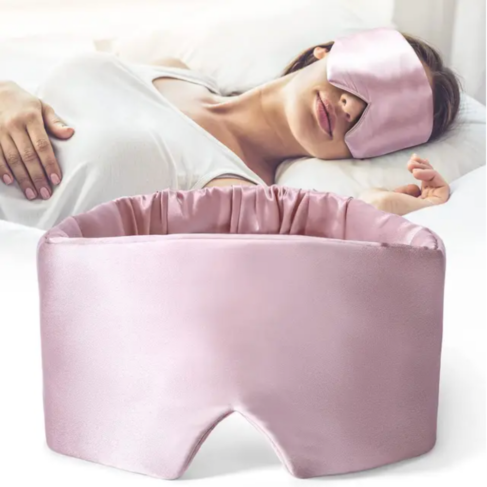 Luxurious unisex silk sleep mask, blocks 100% light; shown in elegant black with adjustable strap for comfortable wear.
