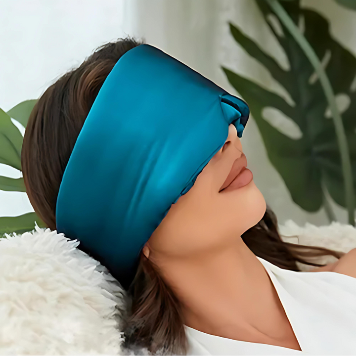 Luxurious unisex silk sleep mask, blocks 100% light; shown in elegant black with adjustable strap for comfortable wear.